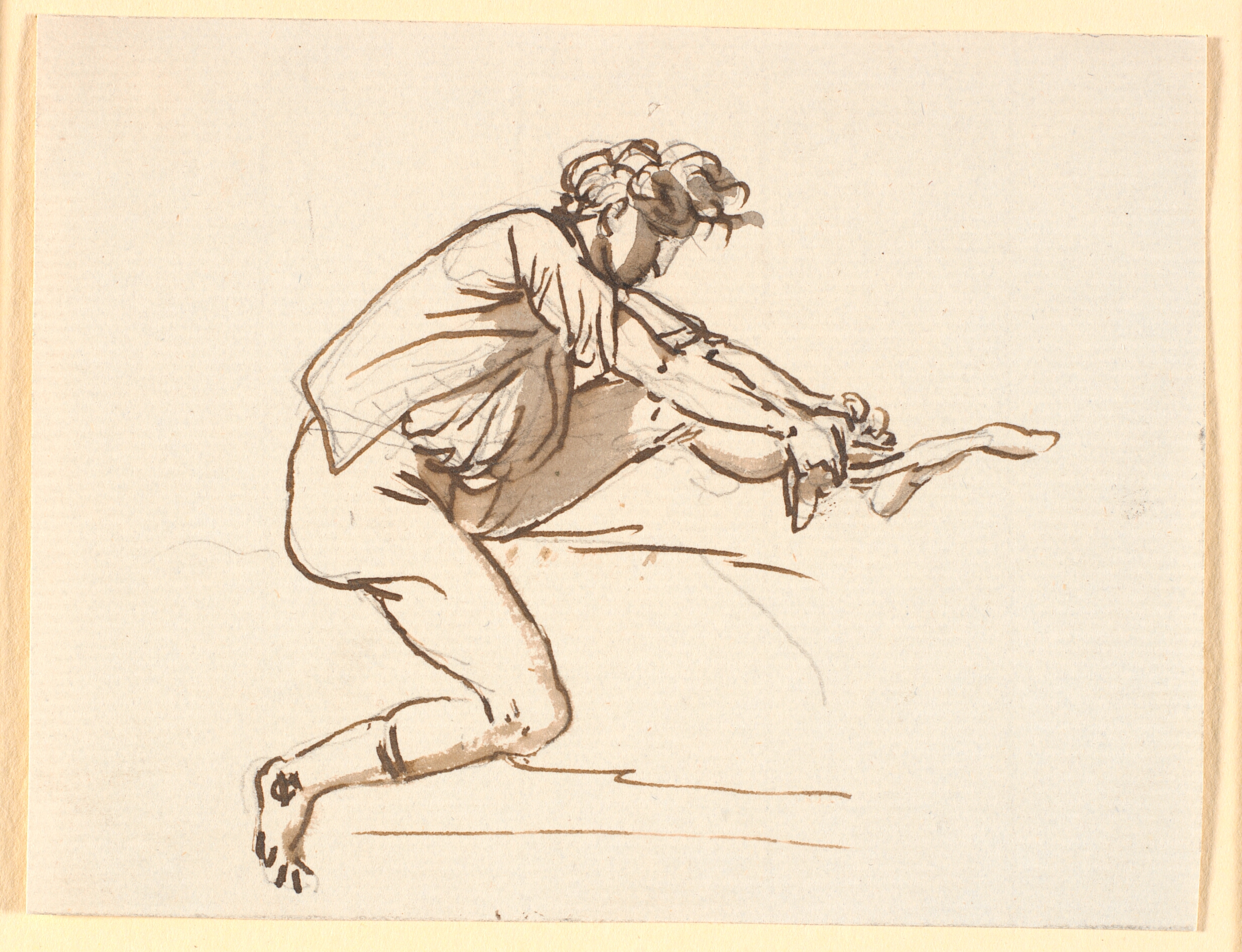 Siddende mand der trækker en strømpe på