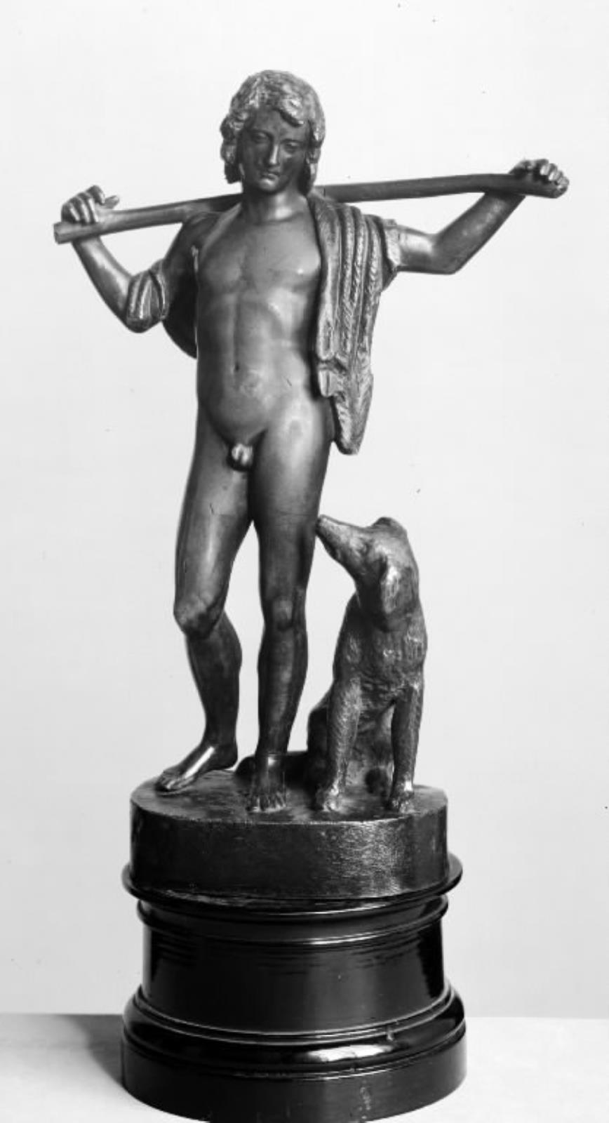 En hyrdedreng. Stående nøgen dreng med en stav over nakken og en hund ved sin side