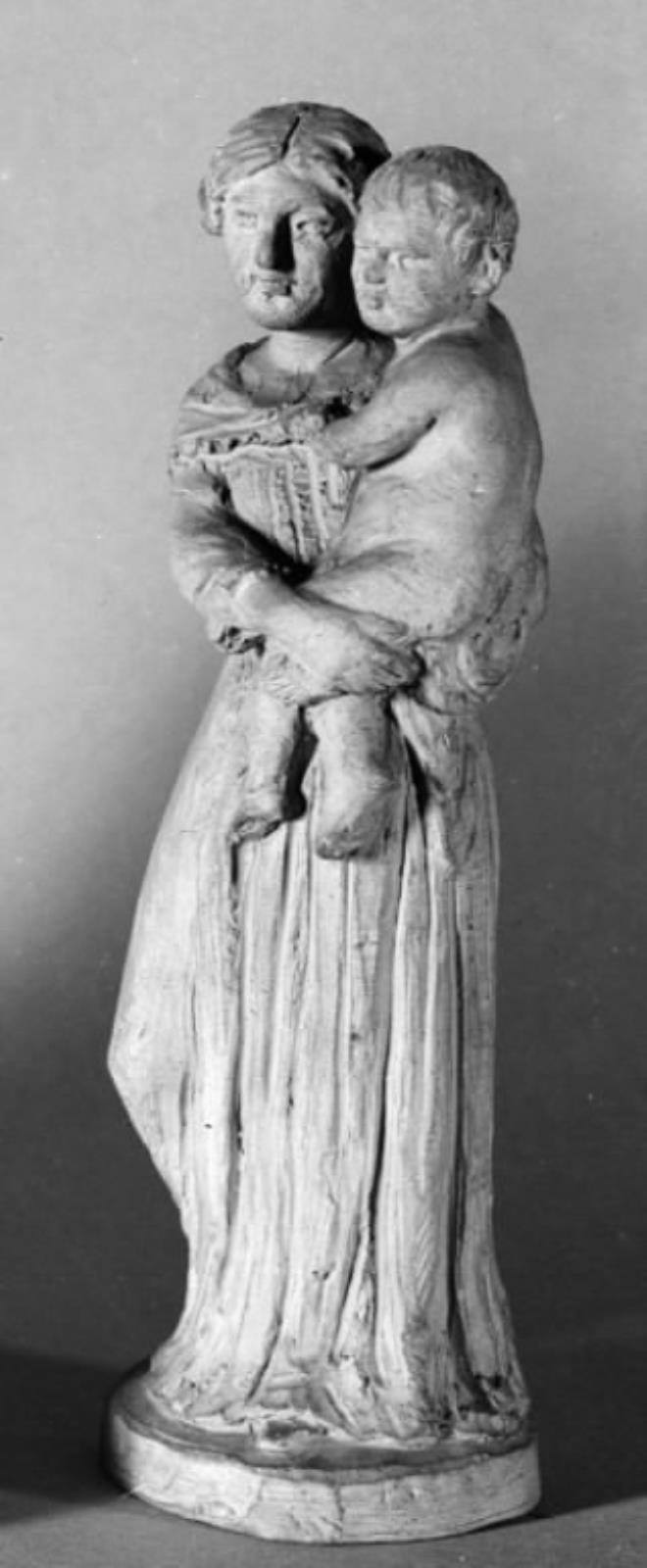 Kvinde stående med et barn på armen