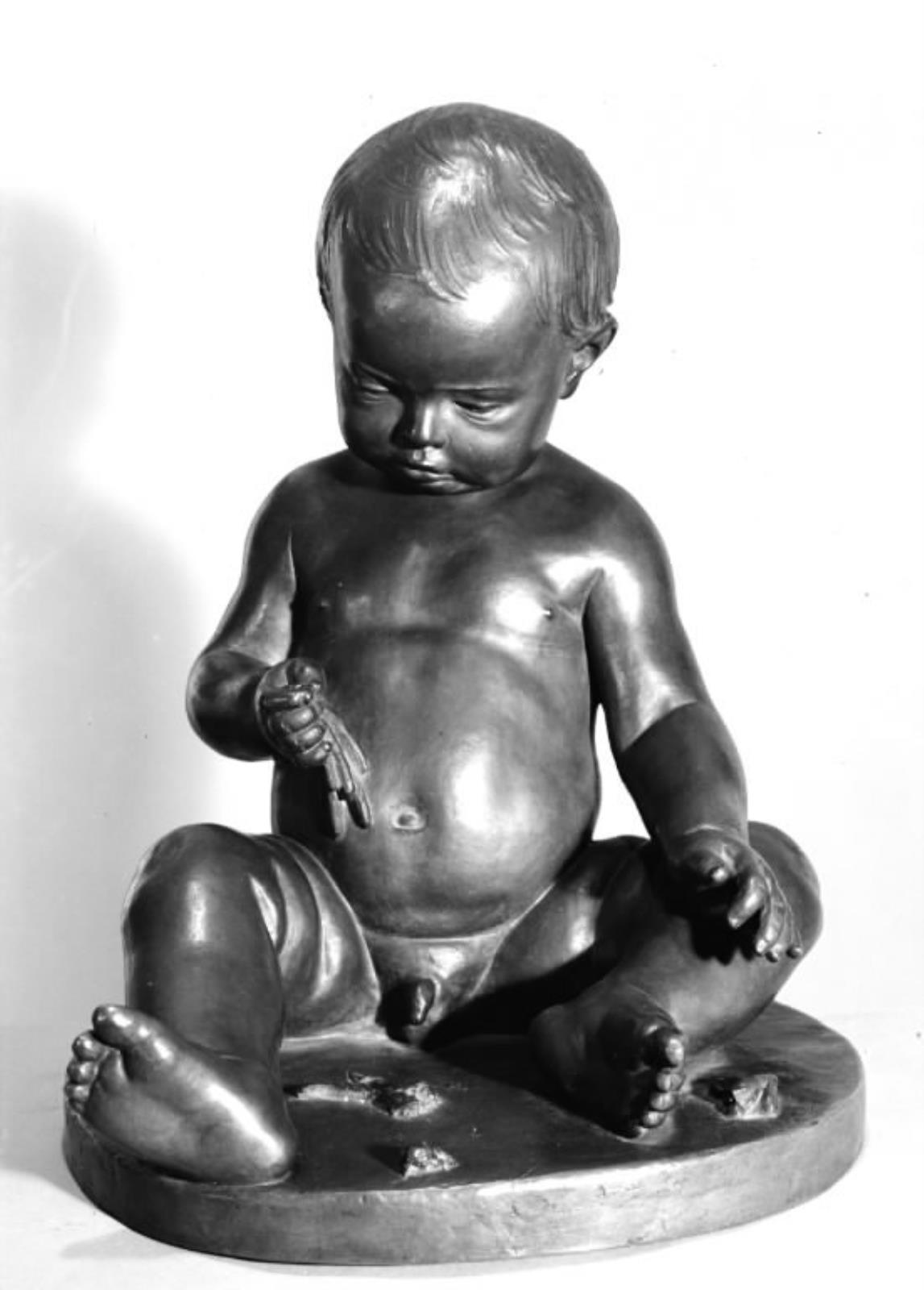 Et barn, der leger med blomster. Siddende nøgen dreng, der piller bladene af en blomst