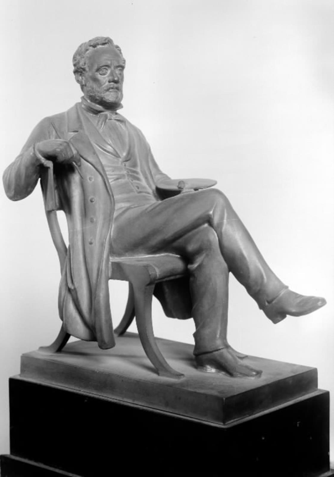 Maleren Wilhelm Marstrand siddende med en pensel og palet i en stol