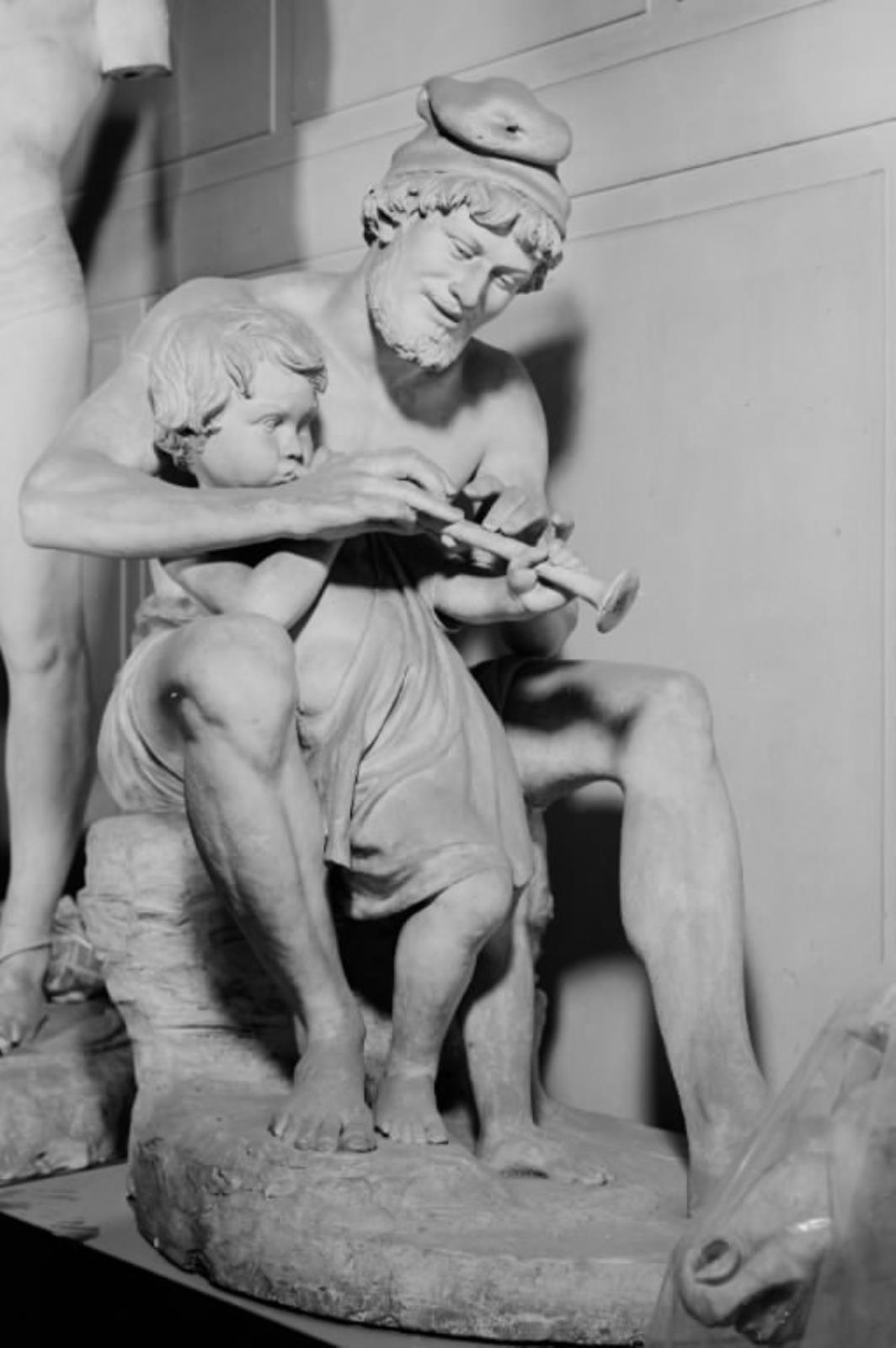 En fisker lærer en lille dreng at spille fløjte