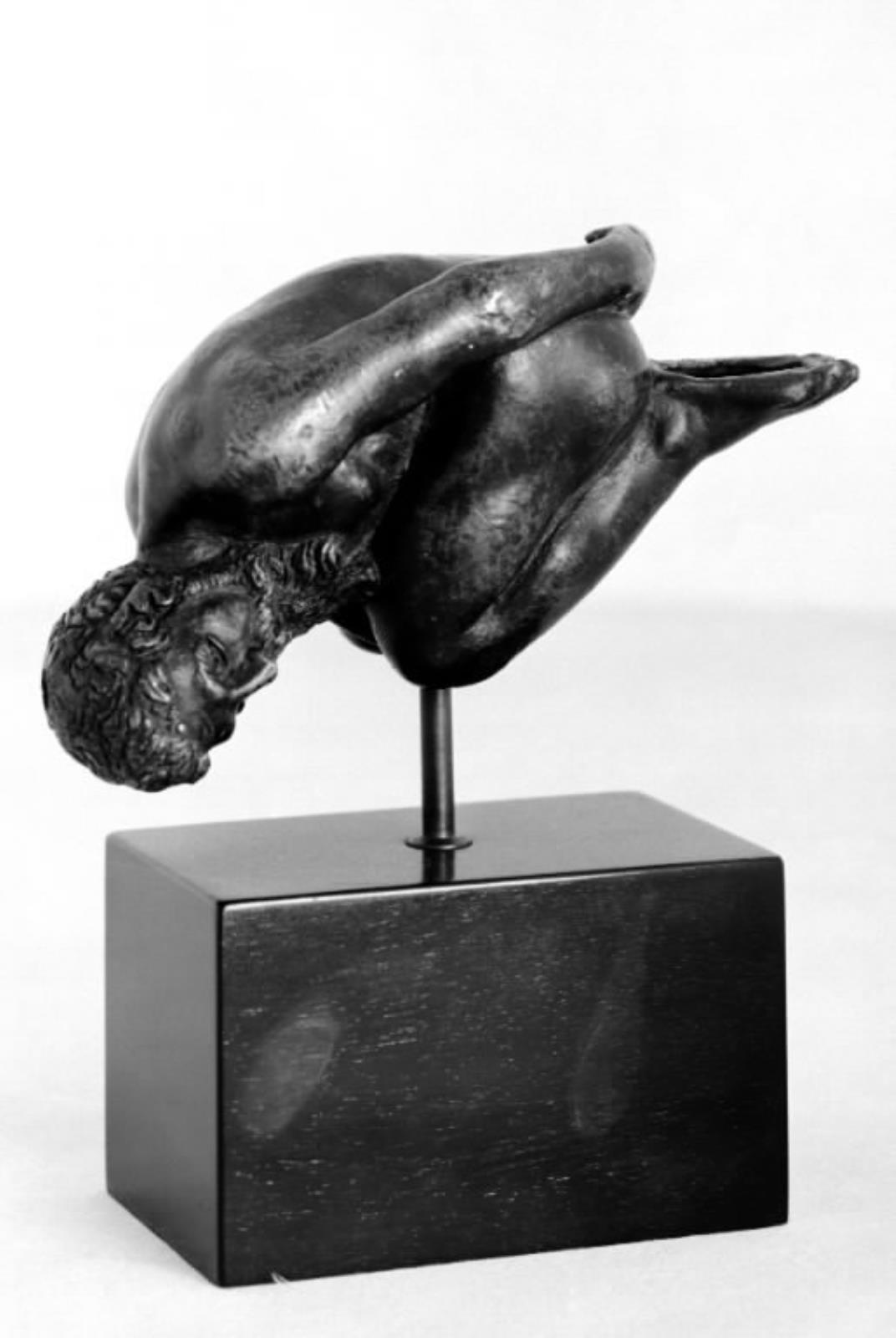 Olielampe(?). Mand, der ligger på knæ